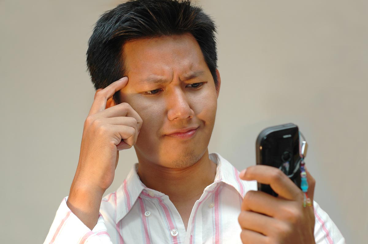 Man-Reading-Text-Message-Confused-Cell-Phone