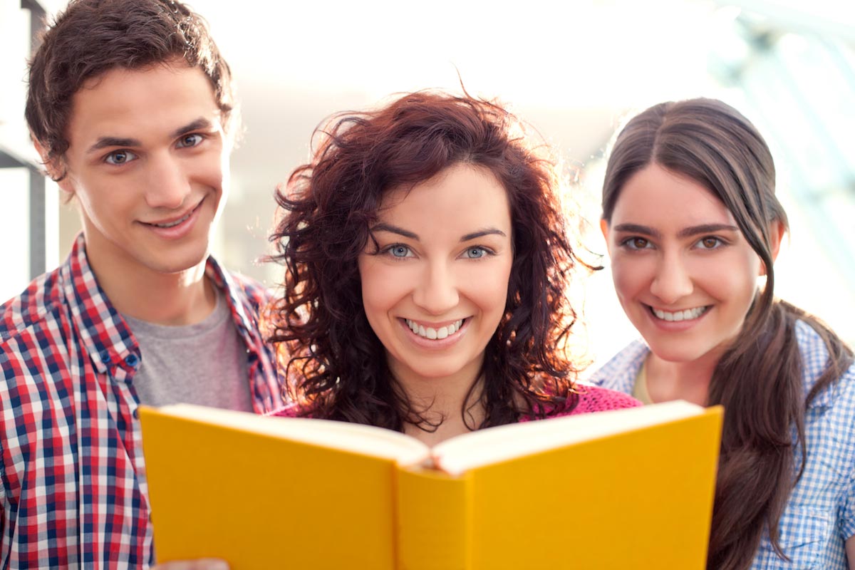 Students-Reading-At-The-Library-Books-Smiling-Friends